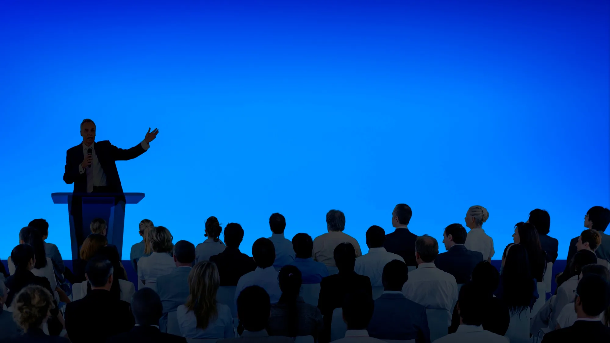 Man in suit addressing a seated audience